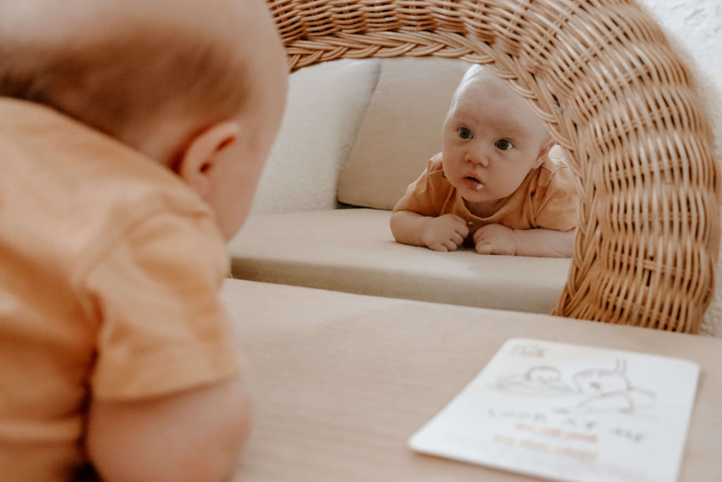 newborn baby using a tummy time mirror